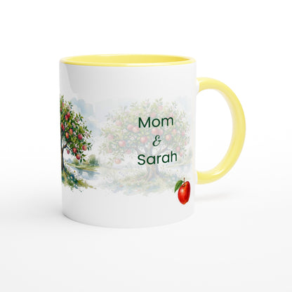 A white ceramic mug with a yellow handle and interior, featuring a watercolor-style apple tree illustration and the personalized text 'Mom & Sarah' on the front.