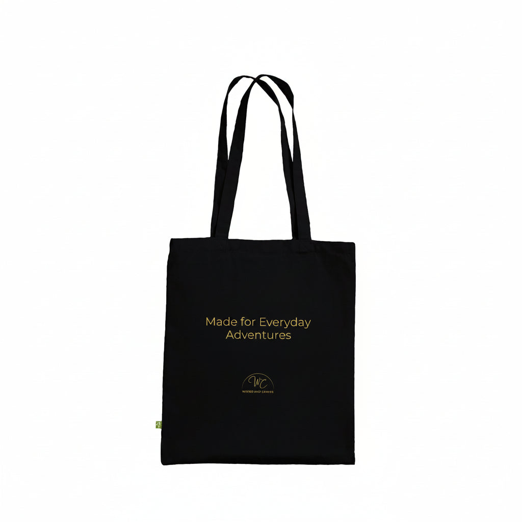 A black canvas tote bag with yellow text reading 'Made for Everyday Adventures' and a small yellow logo near the bottom, shown on a plain white background.