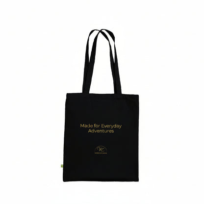 A black canvas tote bag with yellow text reading 'Made for Everyday Adventures' and a small yellow logo near the bottom, shown on a plain white background.