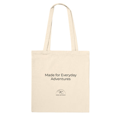 A natural canvas tote bag with black printed text reading 'Made for Everyday Adventures' and a small circular logo below, shown on a plain white background.