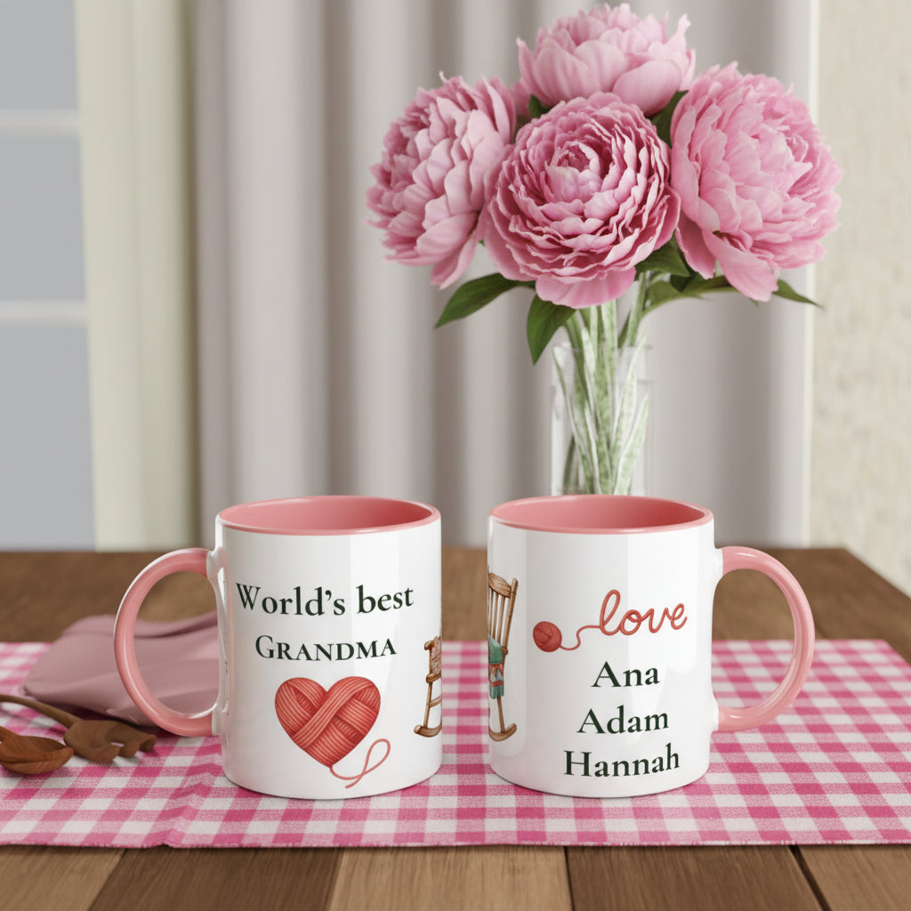 Two personalized ceramic mugs with pink interiors and handles, displayed on a table runner. One mug reads 'World's best GRANDMA' 
