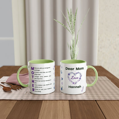 Two ceramic mugs displayed on a wooden table with a placemat, wooden spoon, and a small potted plant in the background. 