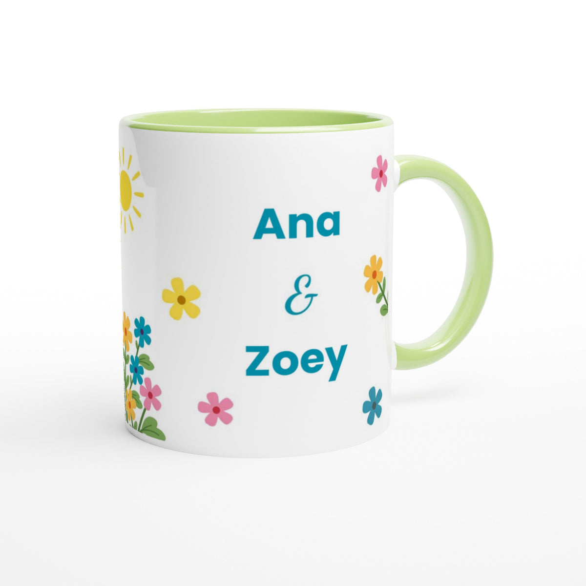A white ceramic mug with a light green handle and interior, decorated with colorful flowers and the personalized names 'Ana & Zoey' in teal text.