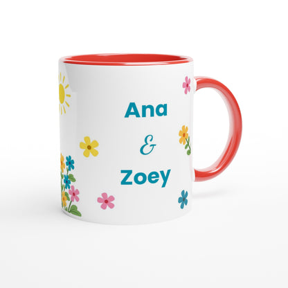 A white ceramic mug with a red interior and red handle, decorated with colorful floral prints and the personalized names 'Ana & Zoey' in teal text.