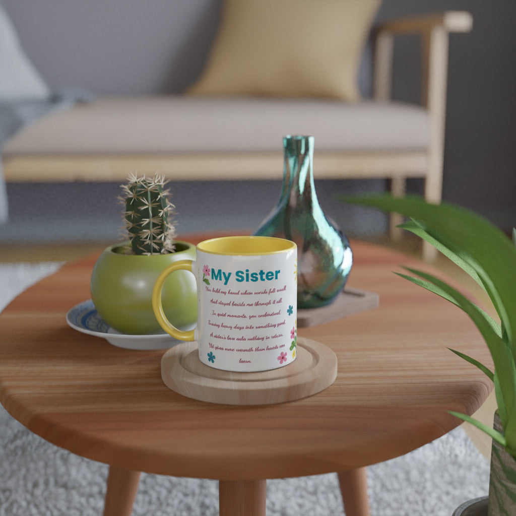 A white ceramic mug with a yellow interior and handle, printed with the text 'My sister' and a poem, sitting on a wooden coaster on a round wooden table in a cozy living room setting.
