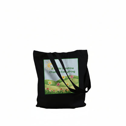 A black tote bag with a meadow graphic against a white background