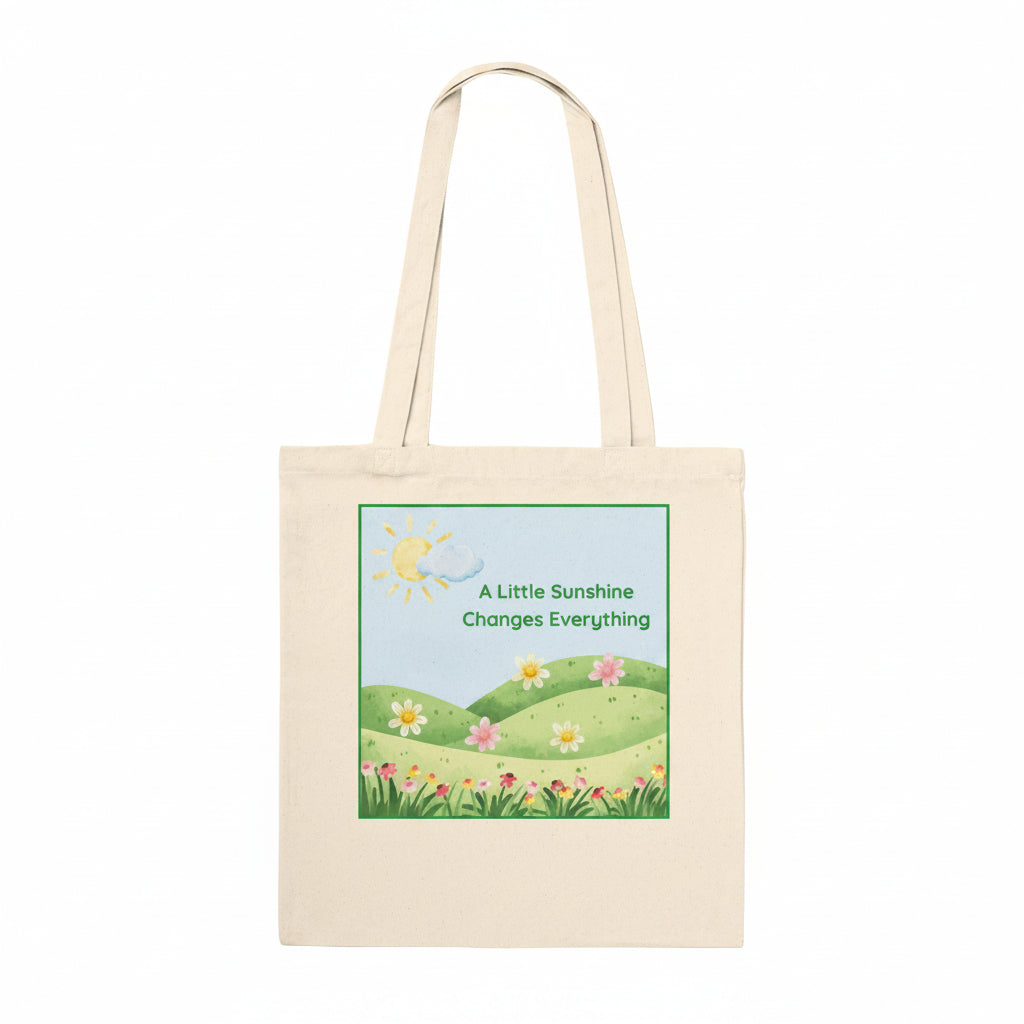 A natural coloured tote bag, with a flowers and meadow graphic and quote "A little sunshine changes everything".