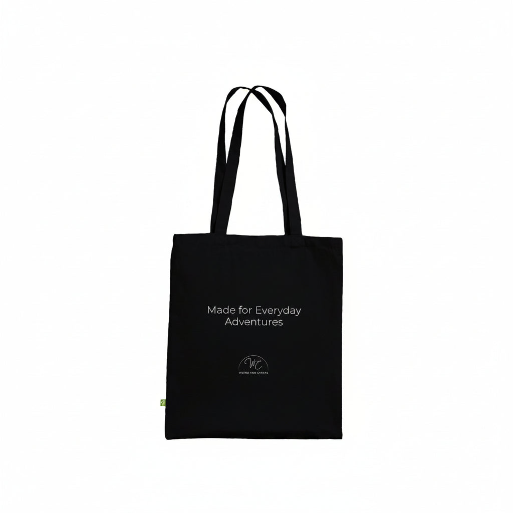 A black canvas tote bag with white printed text reading 'Made for Everyday Adventures' and a small circular logo near the bottom, shown on a plain white background.