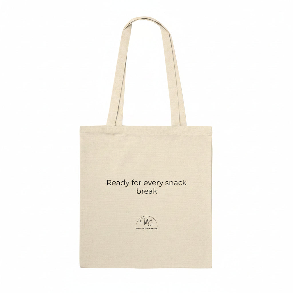 A natural beige canvas tote bag with black printed text reading 'Ready for every snack break' and a small circular logo below, shown on a plain white background.