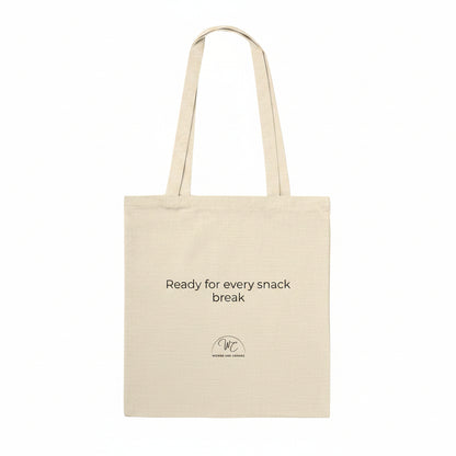 A natural beige canvas tote bag with black printed text reading 'Ready for every snack break' and a small circular logo below, shown on a plain white background.