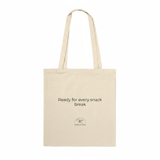 A natural beige canvas tote bag with black printed text reading 'Ready for every snack break' and a small circular logo below, shown on a plain white background.