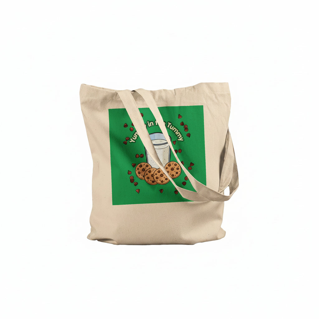 A beige canvas tote bag with a green square graphic on the front featuring a glass of milk, chocolate chip cookies