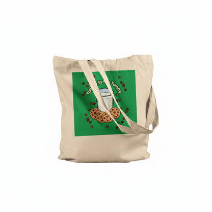 A beige canvas tote bag with a green square graphic on the front featuring a glass of milk, chocolate chip cookies